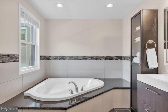 bathroom with a tub, tile patterned floors, and vanity