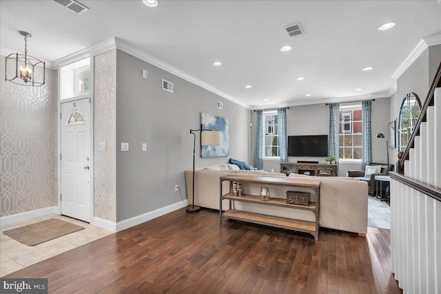 living room featuring a notable chandelier, hardwood / wood-style floors, and crown molding