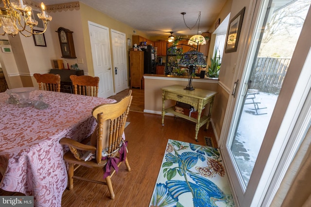 dining space featuring hardwood / wood-style flooring and an inviting chandelier