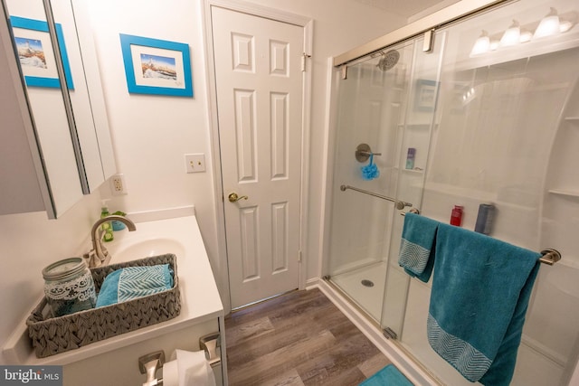 bathroom featuring sink, wood-type flooring, and walk in shower