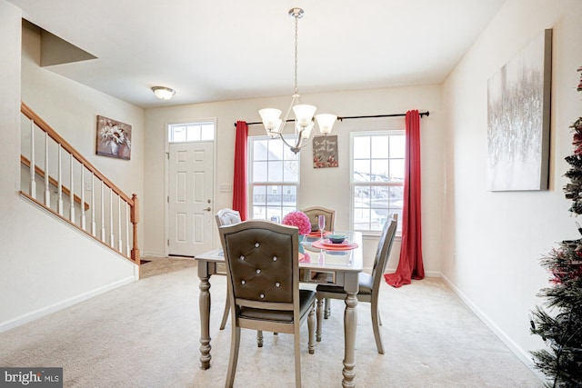 dining room featuring a notable chandelier and light carpet