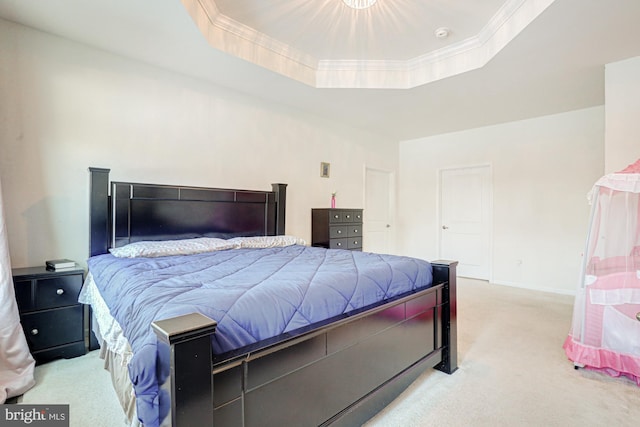 bedroom featuring crown molding, light colored carpet, and a tray ceiling