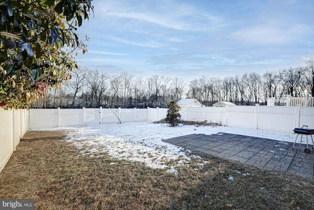 snowy yard with a patio area