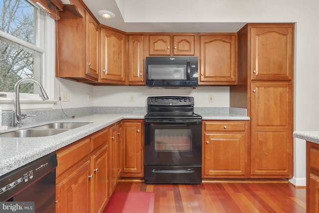 kitchen with sink, dark hardwood / wood-style floors, and black appliances