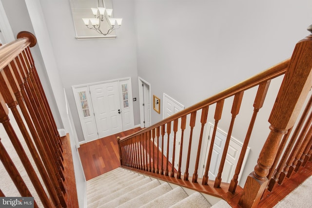 staircase with a notable chandelier and a high ceiling