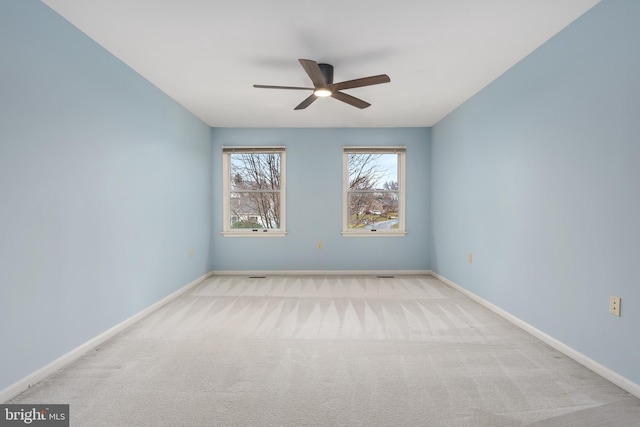 empty room featuring light colored carpet and ceiling fan