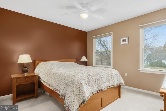 carpeted bedroom featuring multiple windows and ceiling fan