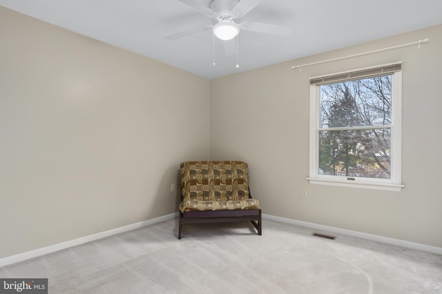 living area featuring carpet floors and ceiling fan