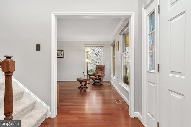 hallway featuring ornamental molding and dark hardwood / wood-style flooring