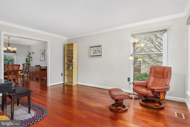 sitting room featuring crown molding, dark hardwood / wood-style flooring, an inviting chandelier, and a wealth of natural light