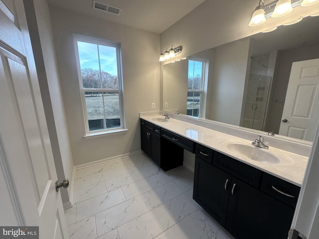 bathroom featuring a shower with door and vanity