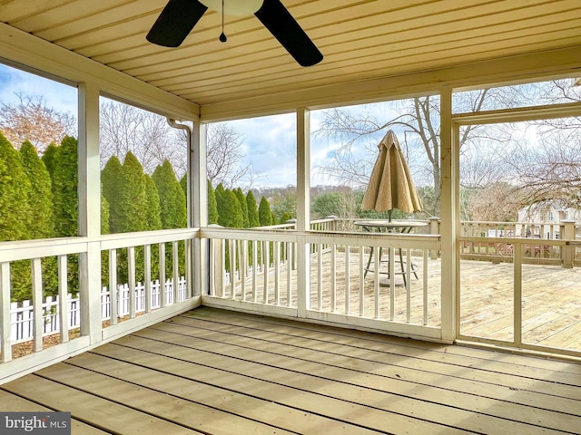 unfurnished sunroom featuring ceiling fan