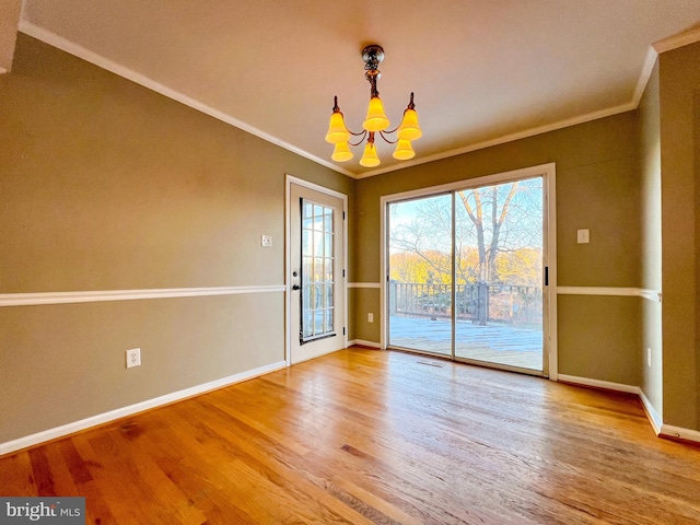 unfurnished dining area with an inviting chandelier, hardwood / wood-style floors, and crown molding