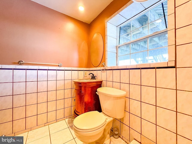 bathroom featuring tile patterned flooring, vanity, tile walls, and toilet