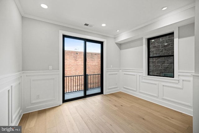 empty room with light hardwood / wood-style floors and ornamental molding