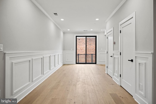 hallway featuring light wood-type flooring and ornamental molding