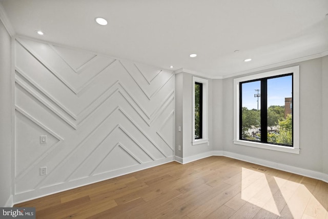 spare room featuring light hardwood / wood-style flooring and ornamental molding