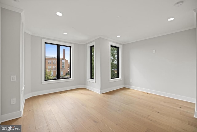 spare room with crown molding and light hardwood / wood-style floors