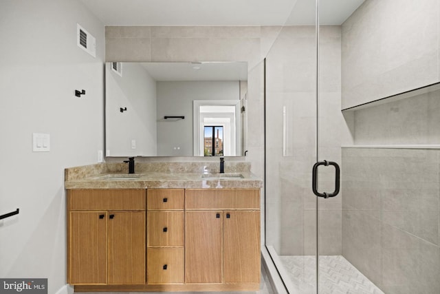 bathroom featuring vanity and a shower with door