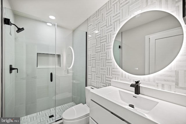 bathroom featuring vanity, toilet, and a shower with shower door