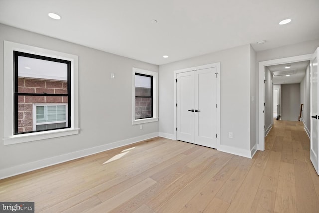 unfurnished bedroom featuring light hardwood / wood-style floors and a closet