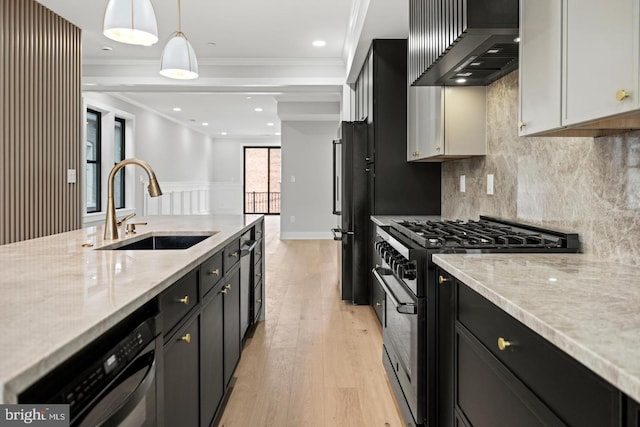 kitchen featuring pendant lighting, sink, premium range hood, white cabinetry, and high end stove