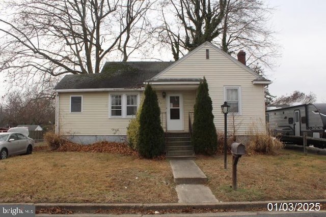 bungalow featuring a front lawn