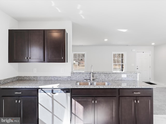 kitchen with dark brown cabinets, sink, stainless steel dishwasher, and light stone counters