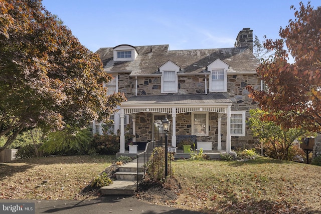 view of front of property with a front yard and a porch