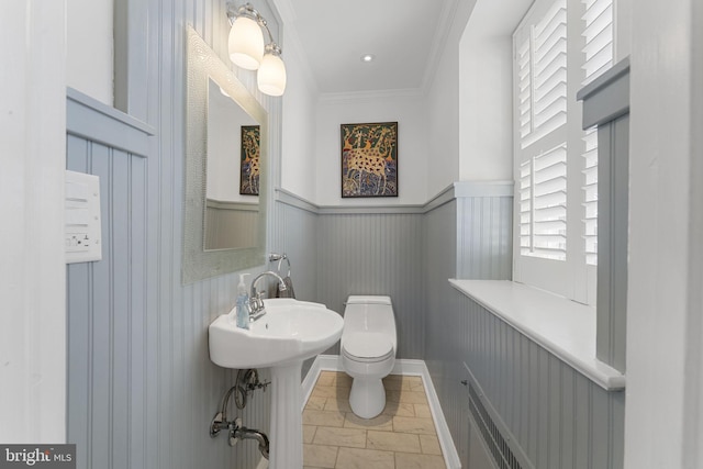 bathroom featuring crown molding and toilet