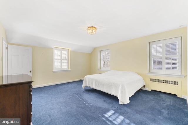 carpeted bedroom with radiator and vaulted ceiling