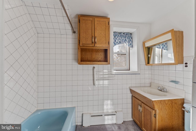 bathroom with tile walls, a baseboard heating unit, and vanity