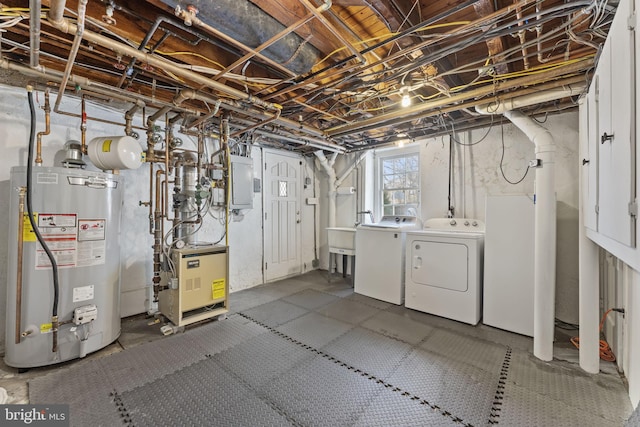 basement featuring gas water heater, separate washer and dryer, and electric panel