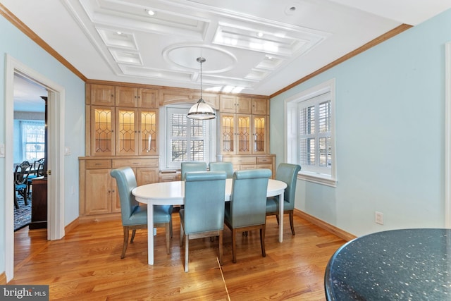 dining space featuring coffered ceiling, crown molding, and light hardwood / wood-style flooring