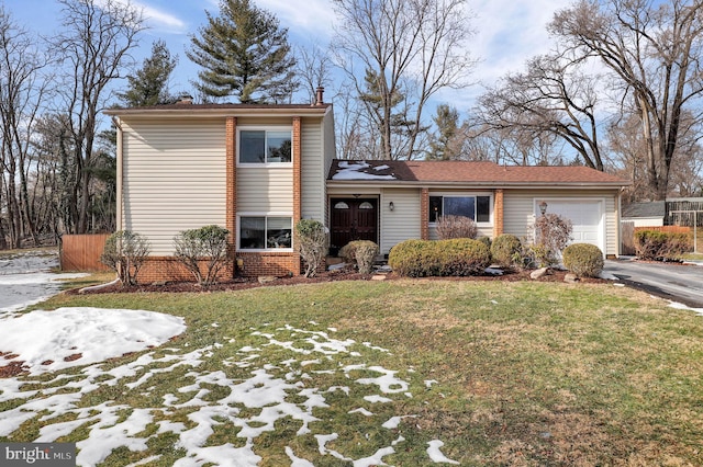 tri-level home featuring a garage and a front yard