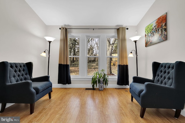 sitting room featuring lofted ceiling and light wood-type flooring