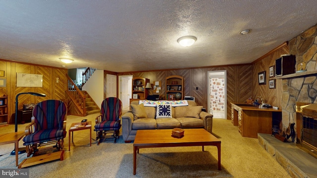 carpeted living room featuring a stone fireplace, wooden walls, and a textured ceiling