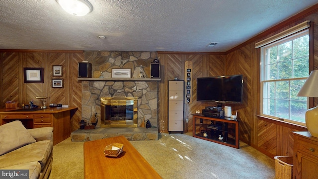 living room with a fireplace, a textured ceiling, wood walls, and carpet flooring