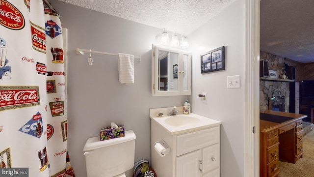 bathroom featuring vanity, toilet, a textured ceiling, and water heater