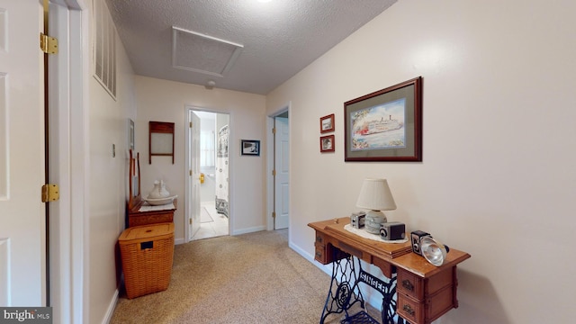 hall with light carpet and a textured ceiling