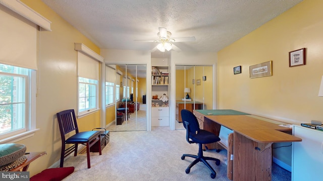 office area featuring light carpet, a textured ceiling, and ceiling fan