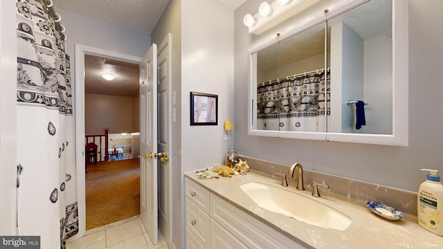 bathroom with vanity, a textured ceiling, and tile patterned flooring