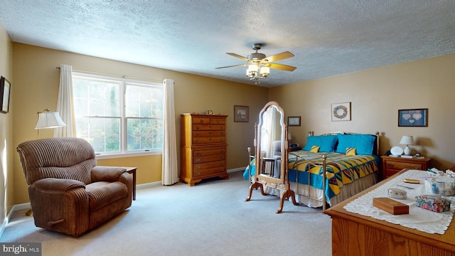 carpeted bedroom with ceiling fan and a textured ceiling