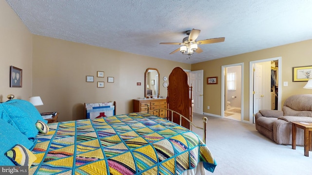 carpeted bedroom featuring ceiling fan, a textured ceiling, and ensuite bath