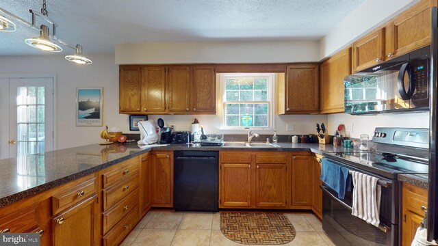 kitchen with sink, black appliances, a textured ceiling, and light tile patterned floors