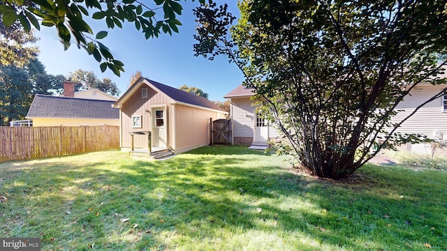 back of house featuring a yard and a storage shed