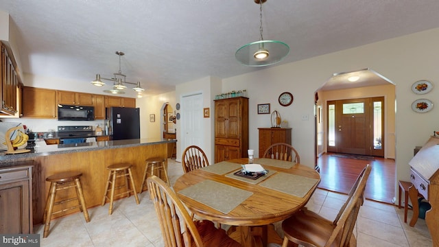 tiled dining area with a textured ceiling