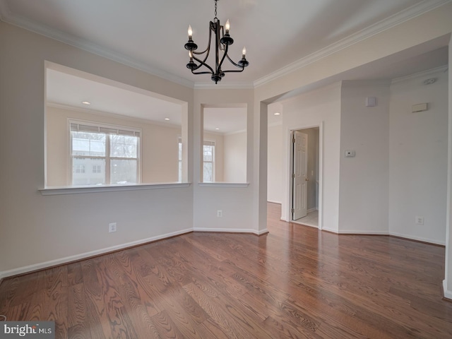 empty room featuring an inviting chandelier, crown molding, and wood-type flooring