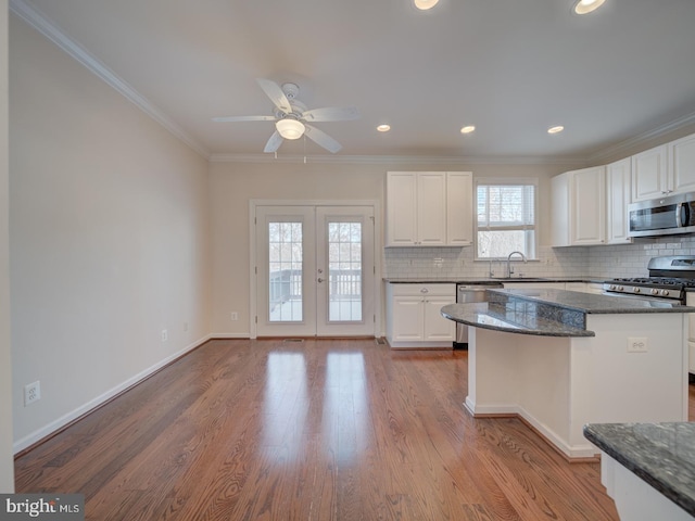 kitchen with stainless steel appliances, white cabinetry, and sink