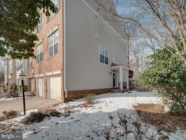 snow covered property with a garage